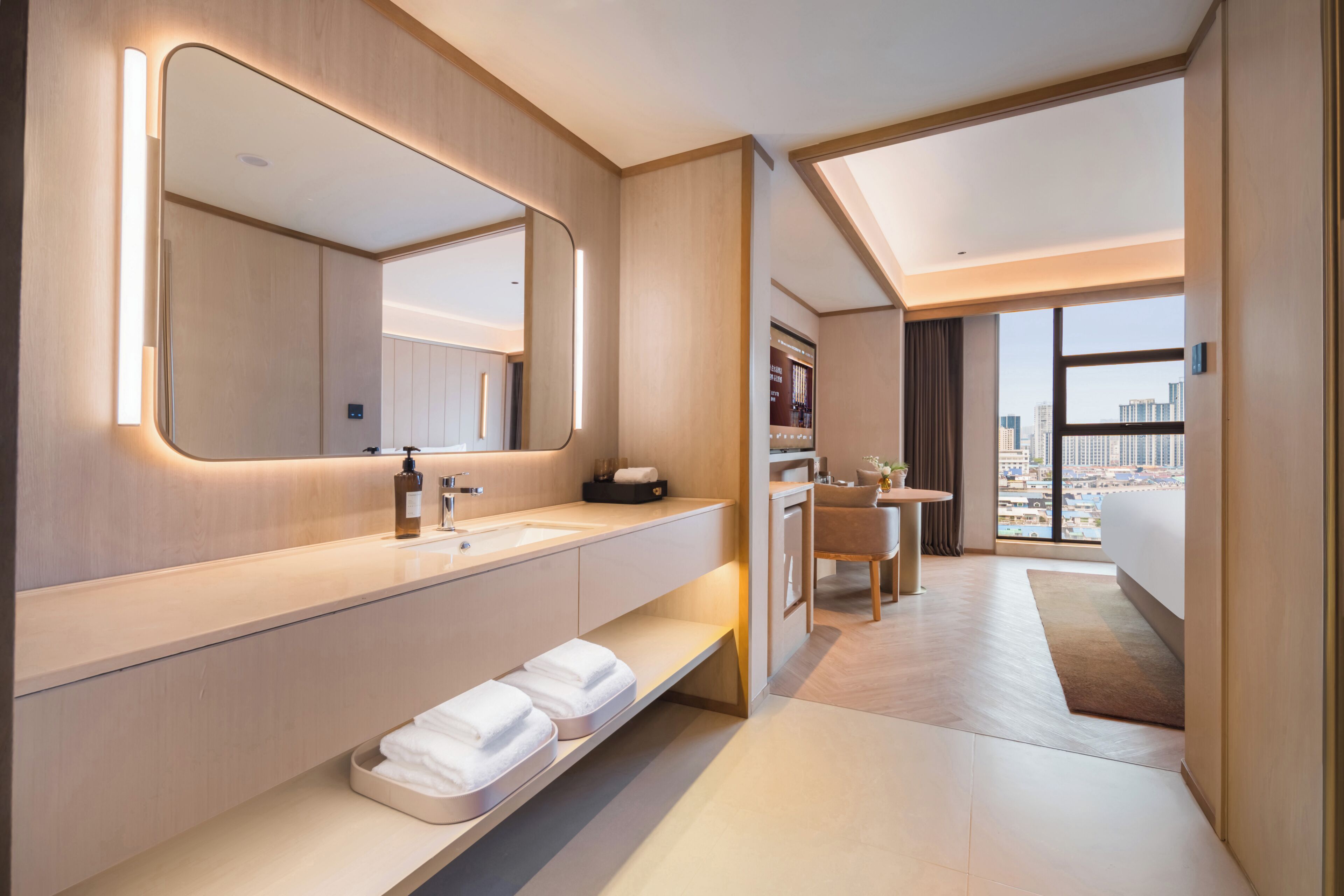 Un baño moderno con un espejo grande, un lavabo y una cómoda. Hay una ventana con vistas a edificios.