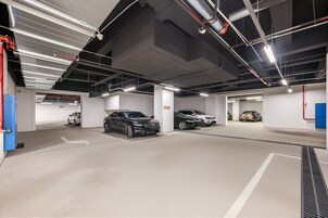 Un estacionamiento subterráneo de varios niveles con varios coches aparcados.