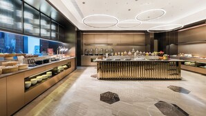 Uma cozinha moderna com ilha central, eletrodomésticos embutidos e diversos dispensadores de alimentos.