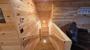 Ein Holzinnenraum mit einer Treppe zu einer Sitzgelegenheit.