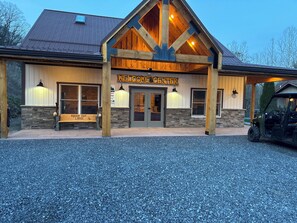 Un edificio con un cartello che indica 'Welcome Center', una panchina con la scritta 'Rough Cut Lodge' e un veicolo parcheggiato di fronte.