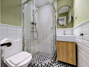 A bathroom with a glass-enclosed shower, a toilet, a sink, and a mirror. - Dinostratus House - Boutique Rooms and Apartments near Acropolis and Metro (Athina)