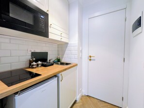 A compact kitchen with a microwave, a small refrigerator, and a sink. - Dinostratus House - Boutique Rooms and Apartments near Acropolis and Metro (Athina)