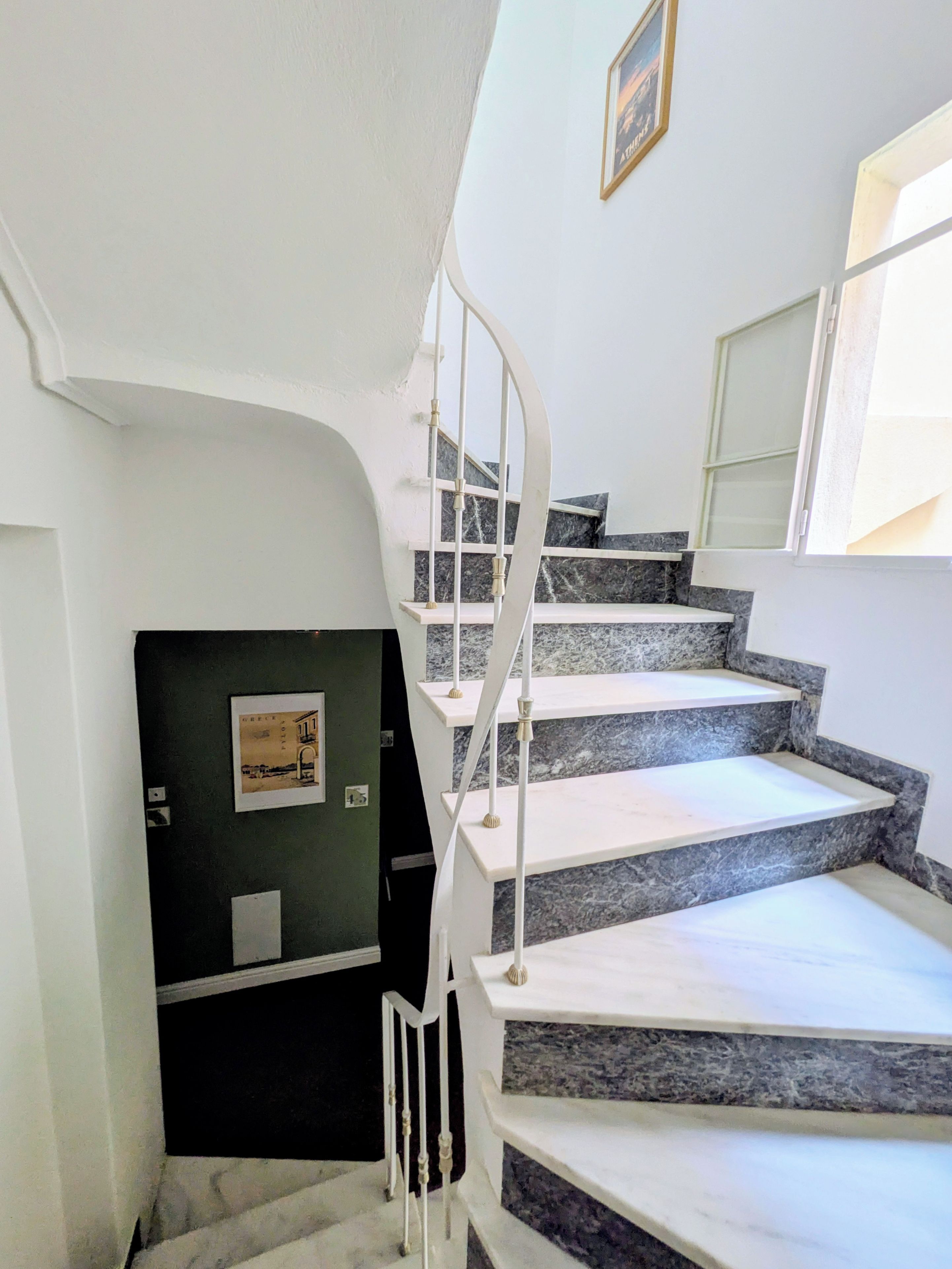 Una escalera con barandillas blancas y escalones de mármol que conduce a una plataforma.