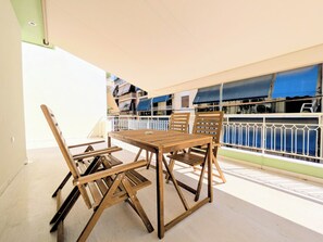 A wooden table and chairs set on a balcony with a view of buildings. - Dinostratus House - Boutique Rooms and Apartments near Acropolis and Metro (Athina)