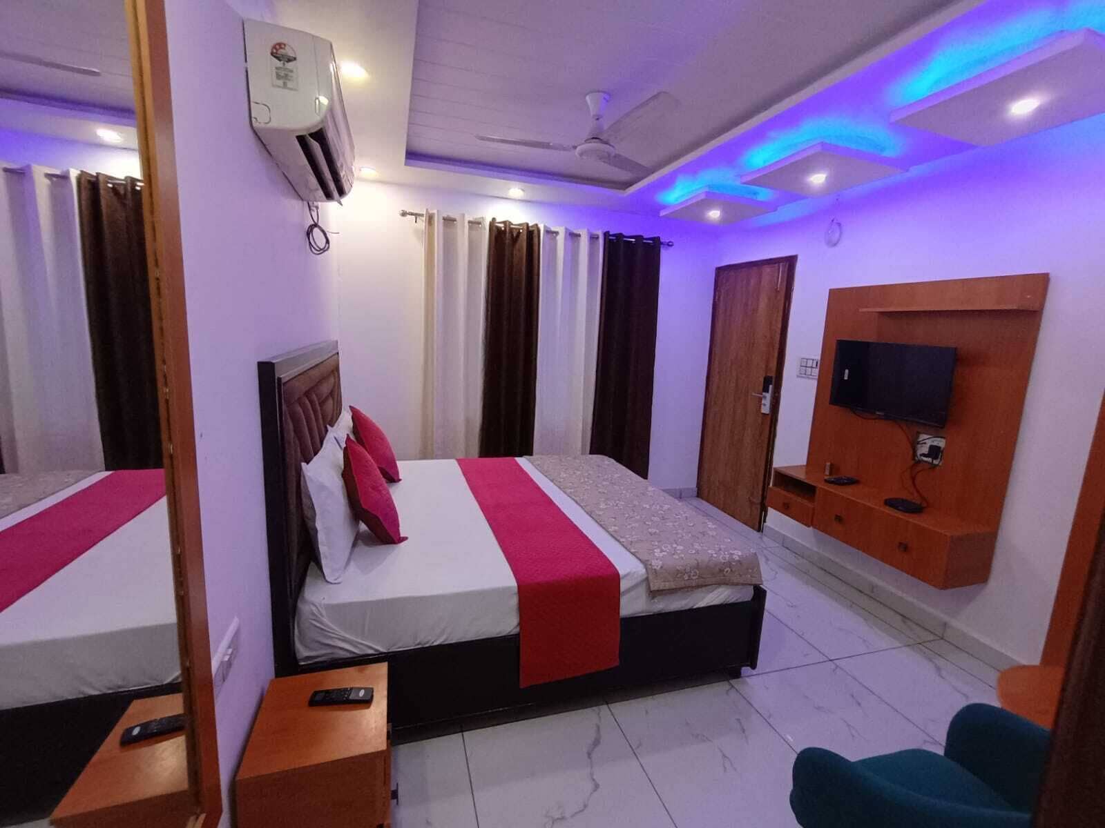 Una habitación de hotel con cama, televisión, escritorio y silla.