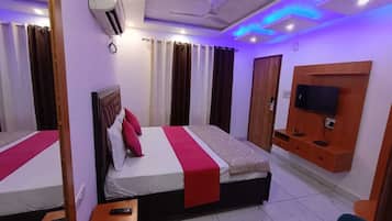 Una habitación de hotel con cama, televisión, escritorio y silla.