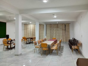 Un salón de conferencias con una mesa larga, varias sillas y una pantalla para proyector.