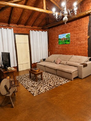 Una sala acogedora con un sofá, una mesa de centro de madera, un televisor y una alfombra estampada.