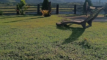 Um campo gramado com um banco de madeira e uma cerca.