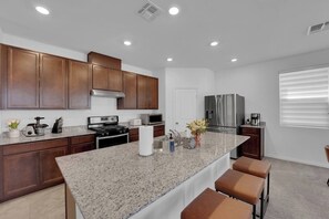 A modern kitchen with granite countertops, stainless steel appliances, and wooden cabinets.