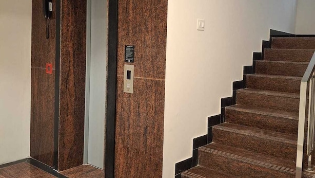 Una escalera con barandilla y una pared con una puerta.