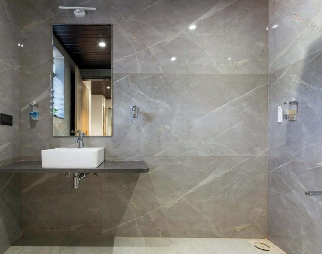 Une salle de bain moderne avec un lavabo blanc, un miroir et un espace douche.