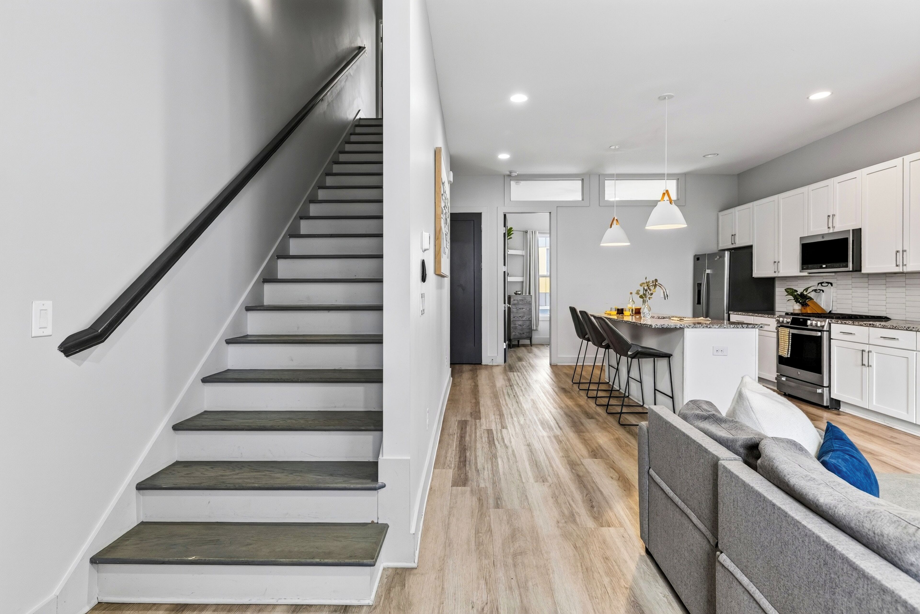 A modern kitchen with white cabinets, a stainless steel refrigerator, and a built-in oven.