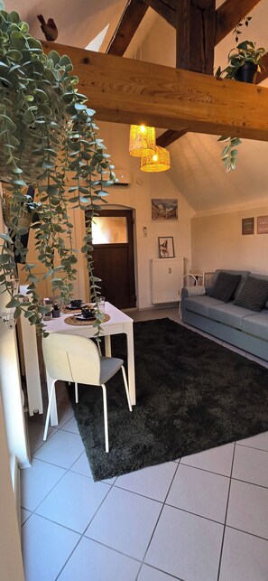 Ein gemütlicher Wohnbereich mit Essplatz, einer Couch und einer Treppe.