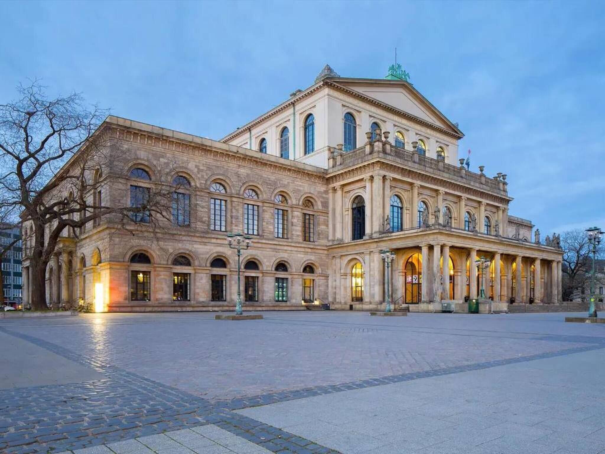 Un grand bâtiment historique à la façade symétrique, doté d’arcs en plein cintre au-dessus des fenêtres et d’une entrée centrale.