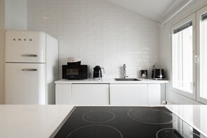 A modern kitchen with a white refrigerator, a microwave, a coffee maker, and a toaster on the countertop. - Taiga Penthouse, Private Sauna By Lapland Host (Rovaniemi)