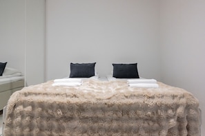 A bedroom with a bed, two pillows, and a fluffy blanket. - Taiga Penthouse, Private Sauna By Lapland Host (Rovaniemi)