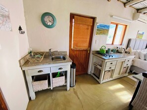 A compact kitchen with a sink, a stove, and a small dining area.