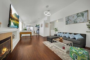 Ein modernes Wohnzimmer mit Kamin, einer Couch, einem Couchtisch und einem Billardtisch.
