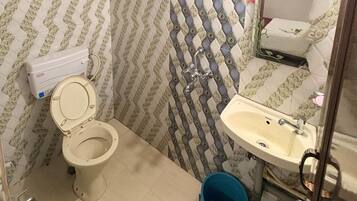 Un baño con inodoro, lavamanos y paredes con diseño.