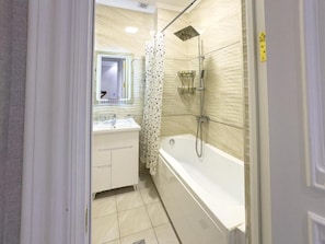 A bathroom with a bathtub, shower, and a mirror. - Yakkasaray Premium Apartment 2 (Tashkent)