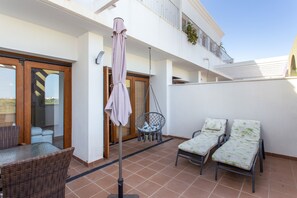 A patio with wicker furniture, a hanging chair, and a pair of lounge chairs with cushions. - Apartment 'Casa De Panorama' with Lake View, Wi-Fi and Air Conditioning (Xeresa)