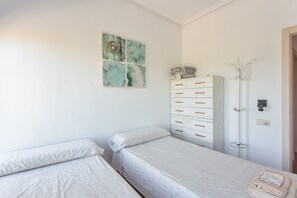 A bedroom with two single beds, a white wardrobe with multiple drawers, and a coat rack. - Apartment 'Casa De Panorama' with Lake View, Wi-Fi and Air Conditioning (Xeresa)