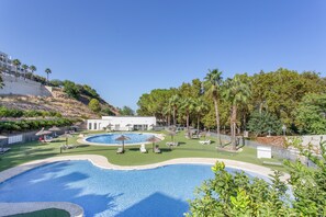 A resort with a swimming pool, lounge chairs, and palm trees. - Apartment 'Casa De Panorama' with Lake View, Wi-Fi and Air Conditioning (Xeresa)