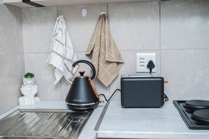 Eine Küche mit Wasserkocher, Toaster und einer weißen Statue auf der Arbeitsplatte.