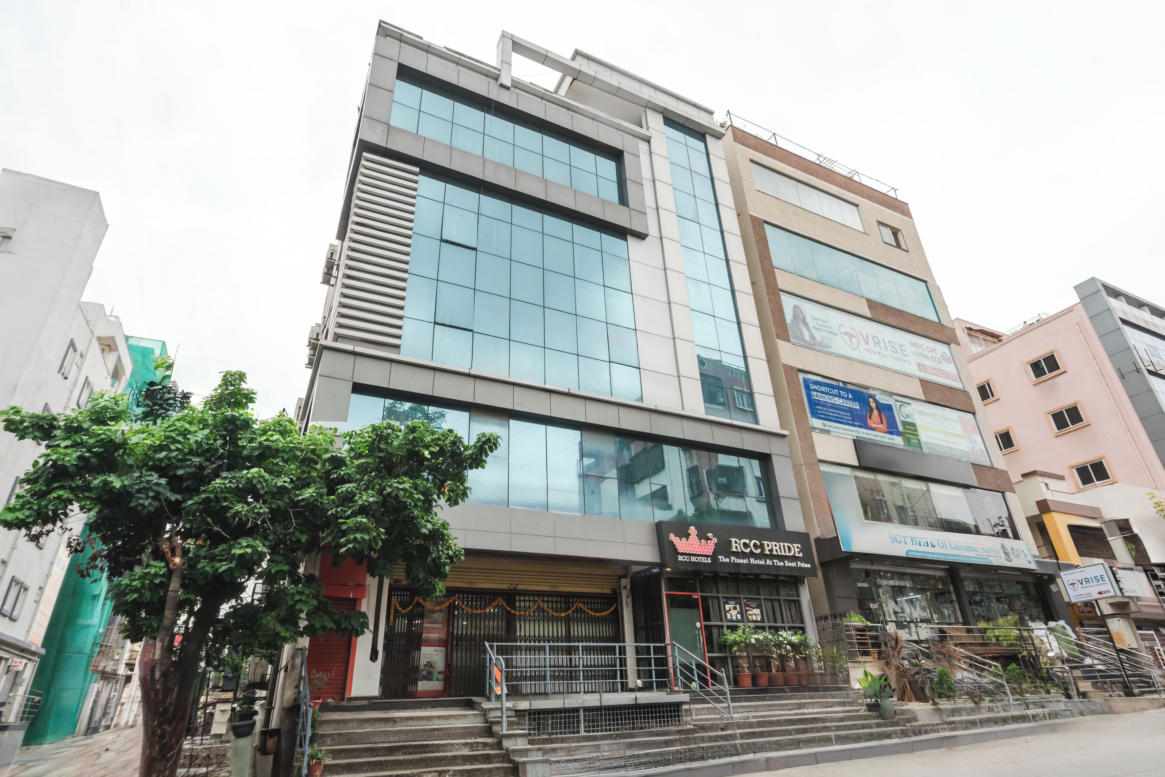 A multi-story hotel with a modern facade, featuring large windows and a prominent entrance with steps leading up to the door.