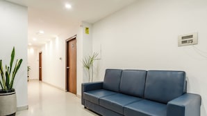 A hallway with a blue sofa, a potted plant, and a door labeled '104'.