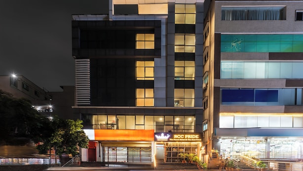 A modern hotel with multiple floors, large windows, and a prominent entrance with a sign.