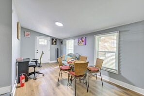 A room with a dining table, chairs, a sofa, a standing heater, and a fire extinguisher. - Centrally Located Charlotte Home w/ Patio & Yard! (Charlotte)