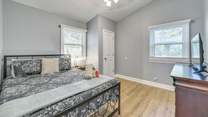 Ein Schlafzimmer mit Bett, Schreibtisch und Deckenventilator.
