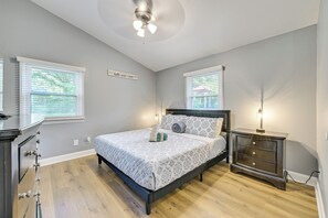 A bedroom with a bed, bedside tables, a ceiling fan, and windows with blinds. - Centrally Located Charlotte Home w/ Patio & Yard! (Charlotte)