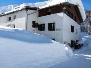 A two-story building with a sign indicating 'butio Allegro' and 'products naturales.' - Fuldera Daint Chasa Zanoli Ferienwohnung im zweiten Stock, (Fuldera) by Interhome (Fuldera)