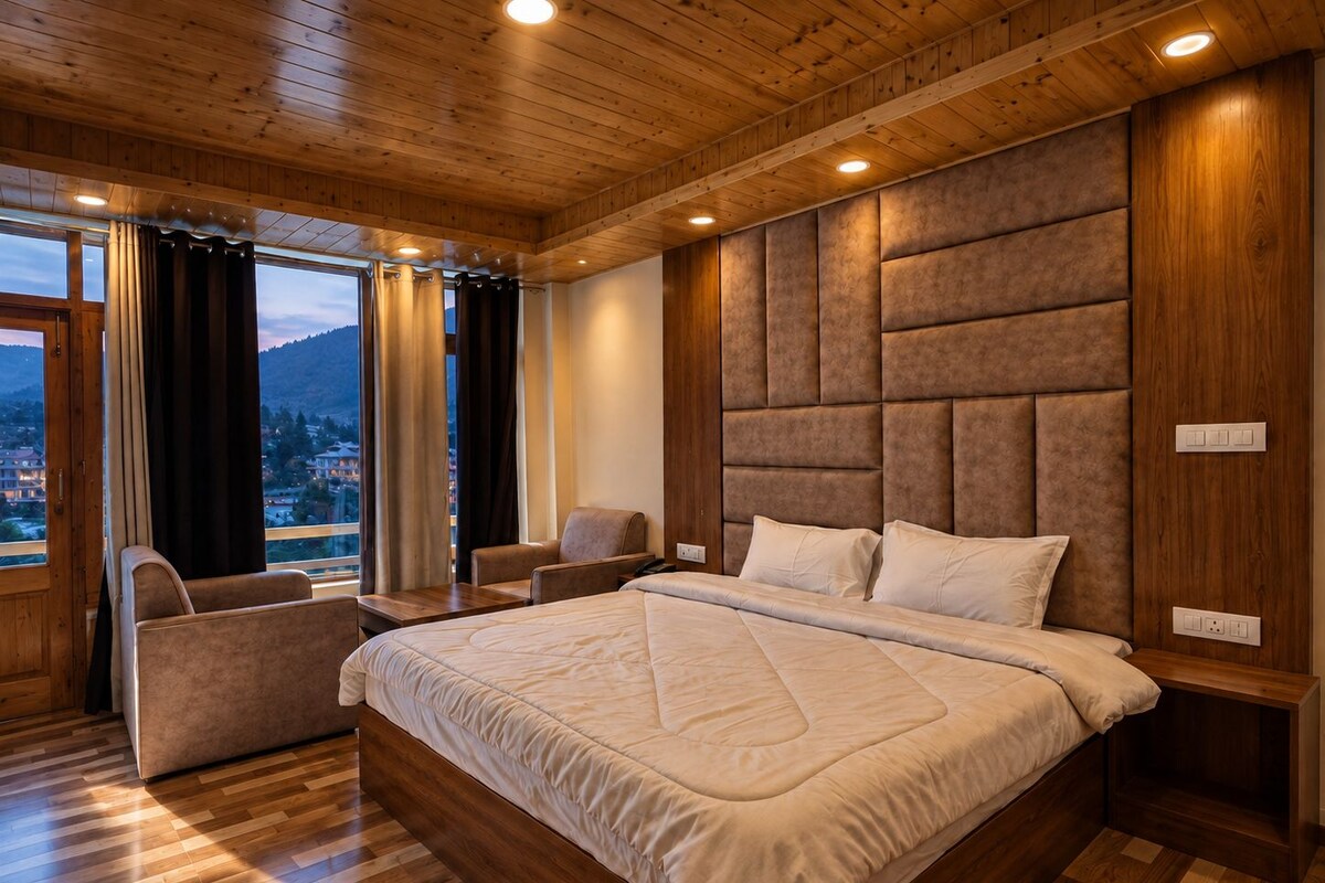 Une chambre dotée d’un grand lit, d’un coin salon avec un fauteuil et d’une vue sur l’extérieur.