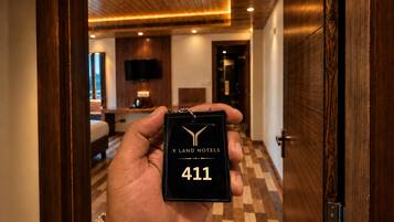 Una mano tiene un portachiavi nero con la scritta 'Y LAND HOTELS' e il numero '411'.