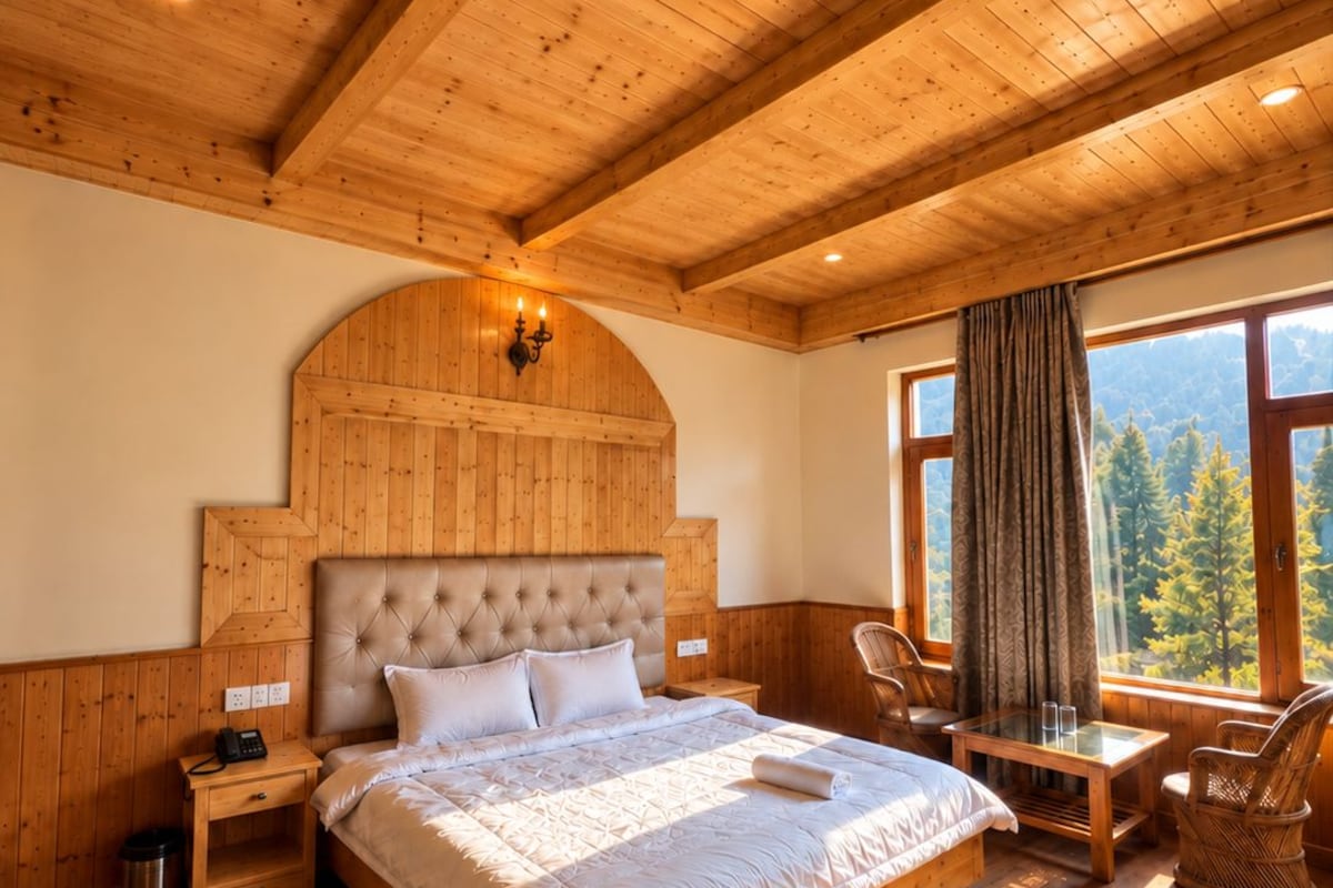 Une chambre à coucher aux murs lambrissés, avec un grand lit, une table de chevet, une lampe et une vue sur les arbres par la fenêtre.