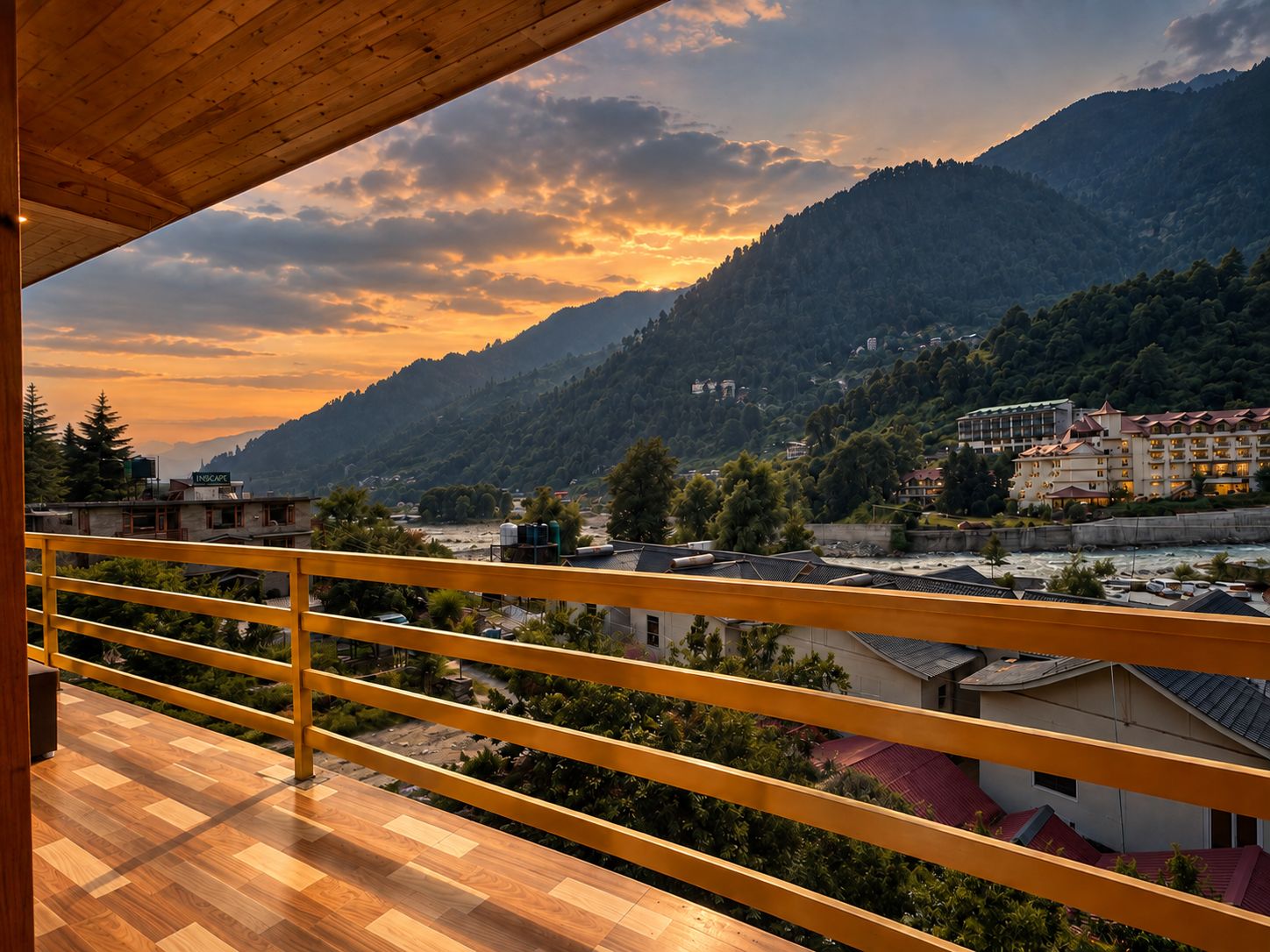 Un balcone con vista su un paesaggio montuoso e un edificio di un hotel sullo sfondo.