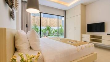 Un dormitorio moderno con cama, mesitas de noche, televisión y vistas al exterior.