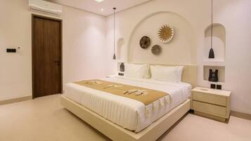 A modern bedroom with a large bed, bedside tables, and decorative wall art.