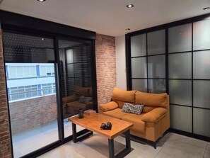 A modern living room with a sofa, a coffee table, and a sliding glass door leading to a balcony. - One-Bedroom Apartment with Terrace, AC and Lift in Central Torremolinos (Torremolinos)