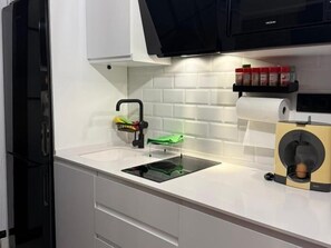 A kitchen with a white countertop, a black faucet, a green cutting board, and a roll of paper towels. - One-Bedroom Apartment with Terrace, AC and Lift in Central Torremolinos (Torremolinos)