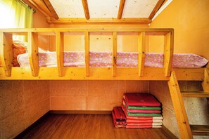 A bunk bed with a wooden frame and a mattress with a floral pattern. - Ddlanchae Hanok Stay - New House (Jeonju)