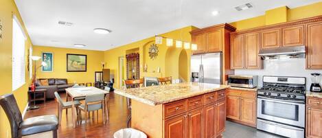 Una cocina moderna con armarios de madera, electrodomésticos de acero inoxidable y encimera de granito.