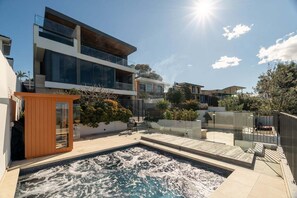 A modern residential property with a swimming pool, outdoor seating, and a multi-level design.