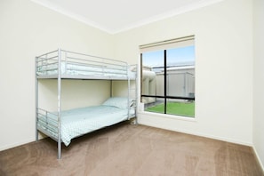 A bunk bed in a room with a large window and a view of an outdoor area. - 24 Shakeshaft Drive, Normanville (Normanville)