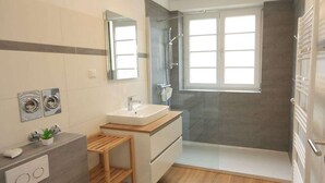 Ein modernes Badezimmer mit Dusche, Waschbecken und Spiegel.